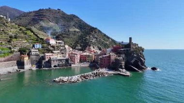 İtalya 'nın Cinque Terre bölgesinde bulunan renkli tarihi bir balıkçı kasabası olan Vernazza' nın çarpıcı hava aracı görüntüleri. Video, canlı evleri, dramatik kıyı şeridini, uçurumları ve Ligurian Denizi 'ni gün ışığında yakalıyor. Seyahat için ideal