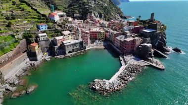 İtalya 'nın Cinque Terre bölgesinde bulunan renkli tarihi bir balıkçı kasabası olan Vernazza' nın çarpıcı hava aracı görüntüleri. Video, canlı evleri, dramatik kıyı şeridini, uçurumları ve Ligurian Denizi 'ni gün ışığında yakalıyor. Seyahat için ideal
