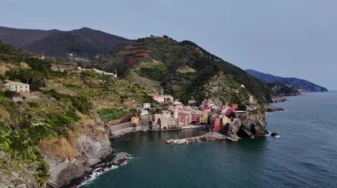 İtalya 'nın Cinque Terre bölgesinde bulunan renkli tarihi bir balıkçı kasabası olan Vernazza' nın çarpıcı hava aracı görüntüleri. Video, canlı evleri, dramatik kıyı şeridini, uçurumları ve Ligurian Denizi 'ni gün ışığında yakalıyor. Seyahat için ideal