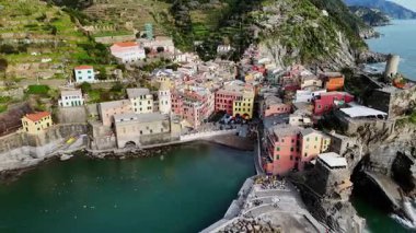 İtalya 'nın Cinque Terre bölgesinde bulunan renkli tarihi bir balıkçı kasabası olan Vernazza' nın çarpıcı hava aracı görüntüleri. Video, canlı evleri, dramatik kıyı şeridini, uçurumları ve Ligurian Denizi 'ni gün ışığında yakalıyor. Seyahat için ideal
