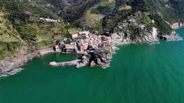 İtalya 'nın Cinque Terre bölgesinde bulunan renkli tarihi bir balıkçı kasabası olan Vernazza' nın çarpıcı hava aracı görüntüleri. Video, canlı evleri, dramatik kıyı şeridini, uçurumları ve Ligurian Denizi 'ni gün ışığında yakalıyor. Seyahat için ideal