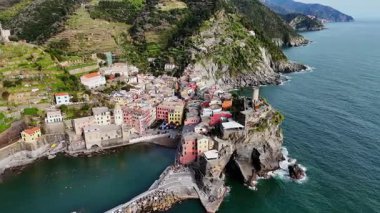 İtalya 'nın Cinque Terre bölgesinde bulunan renkli tarihi bir balıkçı kasabası olan Vernazza' nın çarpıcı hava aracı görüntüleri. Video, canlı evleri, dramatik kıyı şeridini, uçurumları ve Ligurian Denizi 'ni gün ışığında yakalıyor. Seyahat için ideal