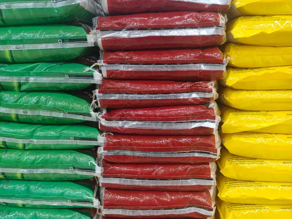 Bir pirinç dükkanında 10 kg ağırlığında renkli plastik pirinç çuvalları - 2 Haziran 2025