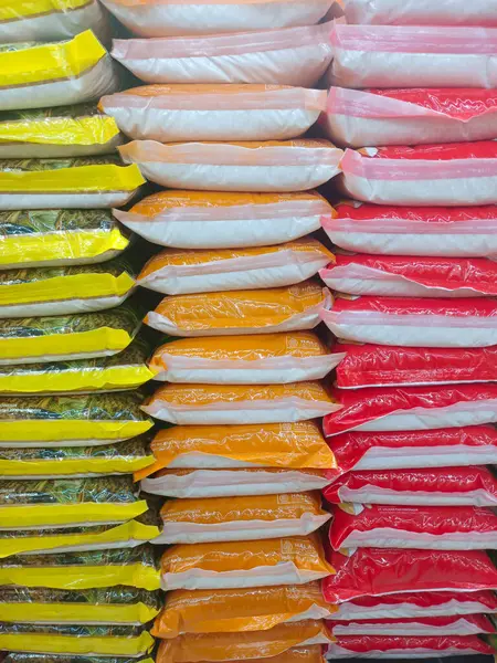 Pirinç pazarında renkli plastik pirinç çuvalları yığını - 2 Haziran 2025