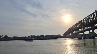 Kapuas 2 Köprüsü sabah güneş doğduğunda kargo gemisi tarafından geçilmiş olacak. Pontianak 'ta..