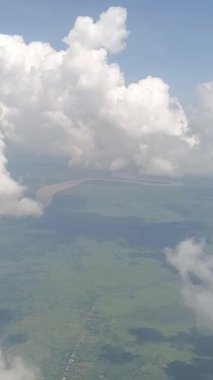 Beyaz bulutlar ve Kapuas Nehri uçak penceresinden görülebilir.