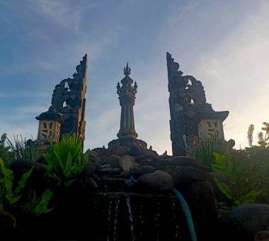 Endonezya 'nın Bali kentindeki Bajra Sandhi Anıtı' nın benzersiz düşük açılı görüntüsü, geleneksel Bali kapıları tarafından çerçevelenmiştir..