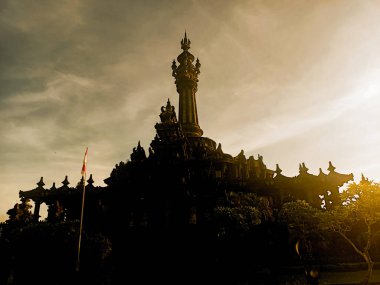 Gün batımında Bajra Sandhi Anıtı 'nın dramatik silueti, Bali.