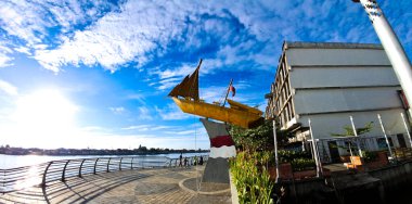 Kapuas Nehri kıyısında parlak mavi gökyüzü manzaralı altın tekne heykeli ve Pontianak 'ta dağınık beyaz bulutlar, 21 Haziran 2025