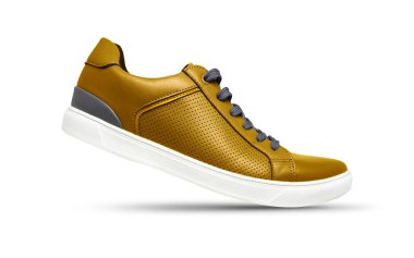 Beyaz arka planda gölgeli altın rengi spor ayakkabılar.