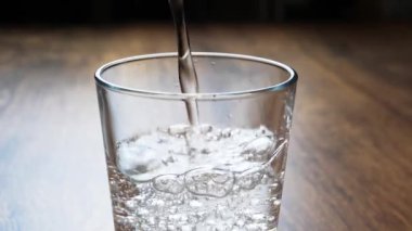 Masadaki içme bardağına taze, soğuk maden suyu döküyorum.