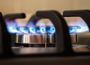 Gas burners lit in modern kitchen. High quality photo clipart