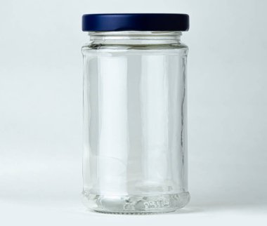 Şeffaf cam bir kavanoz tarafsız bir arkaplanda boş duruyor.