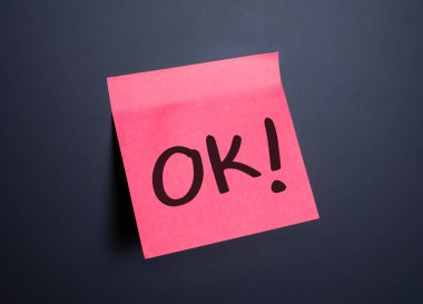 Parlak pembe yapışkan bir not koyu bir arkaplanda 