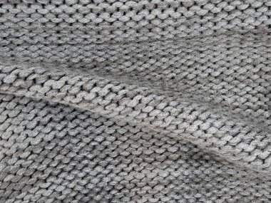 Yumuşak gri örgü kumaş, ayrıntılı desenli sıcak bir doku gösterir