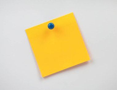 Sarı yapışkan bir not duvara iliştirilmiş, hatırlatıcılar veya notlar için hazır.