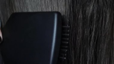 Koyu renk saçları yakından tarıyorum. Yüksek kalite 4k görüntü