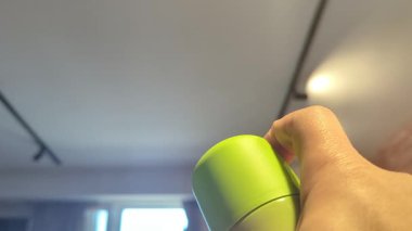 Birisi oturma odasının havasını tazelemek için oda spreyi kullanıyor.