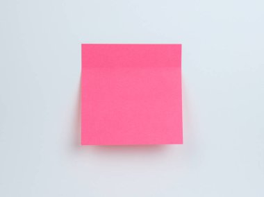 Canlı pembe yapışkan bir not açık bir arkaplanda duruyor, mesajlar için hazır.
