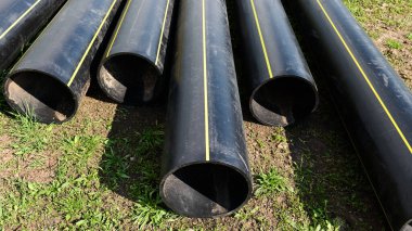 Siyah inşaat boruları yerde yatıyor. Yüksek kalite fotoğraf
