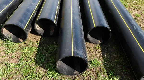 Siyah inşaat boruları yerde yatıyor. Yüksek kalite fotoğraf