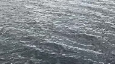 Parıldayan su güneş ışığını yansıtırken nazik dalgalar sorunsuz hareket eder. Yüksek kalite 4k görüntü