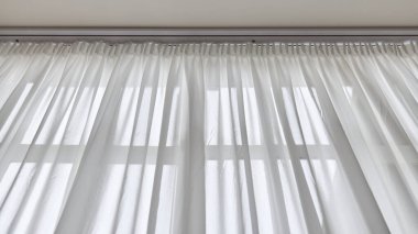 Parlak bir odadaki saf beyaz perdelerin arasından ışık. Yüksek kalite fotoğraf