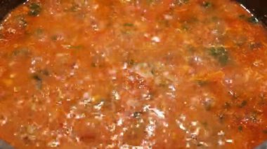 Lezzetli ev yapımı domates sosu yemek hazırlığı için ocakta kaynıyor. Yüksek kalite 4k görüntü