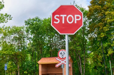 Demiryolu kavşağında parlak kırmızı bir dur işareti var.