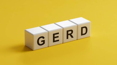 GERD kelimesi tahta küplere yazılır. Tıbbi kavram. Ahşap küplere yakın çekim, sarı arka planda 3D iş konsepti..