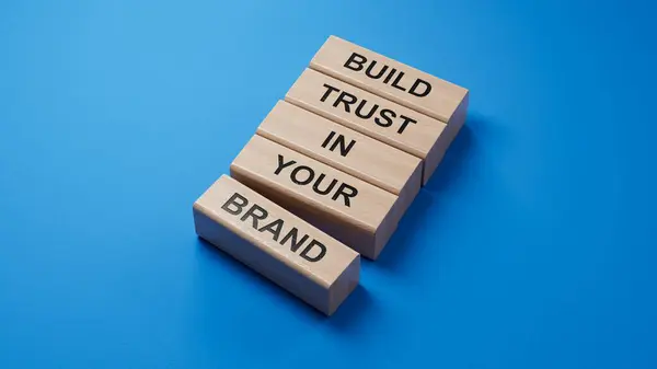 Markanıza güvenin. Sözcüklerle tahta bloklar markanıza güvenin. İş ve marka konseptinize güvenin. Mavi arka planda oluşturulan 3D.