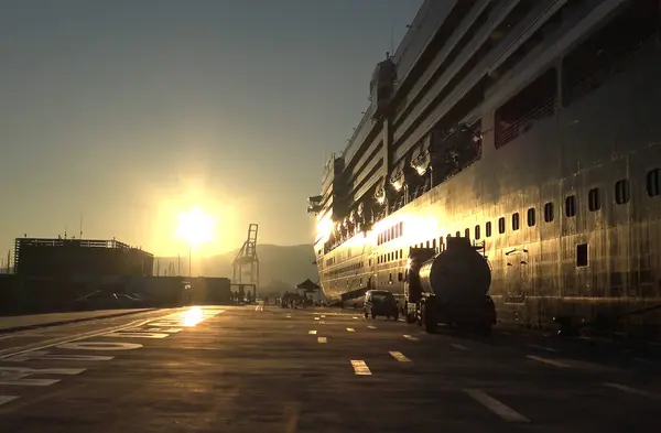 Gemi rıhtıma yanaştı, şafağın altın ışığında yıkandı.