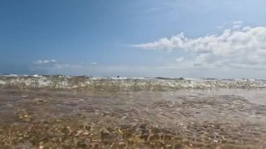 Küçük dalgalar kıyıya yaklaşıyor. Güneşli bir gün