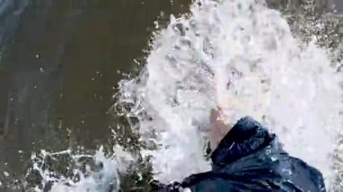 Bir adam sahile giriyor, dalgaların arasından atlarken yavaşça çekilen bacakları..