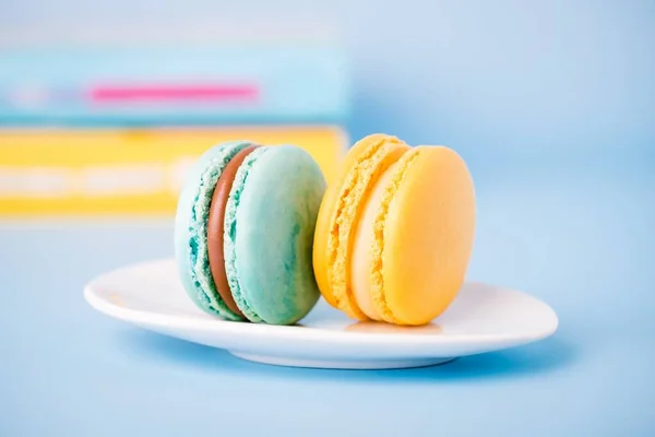 Mint color and yellow sweet macaron on a blue background