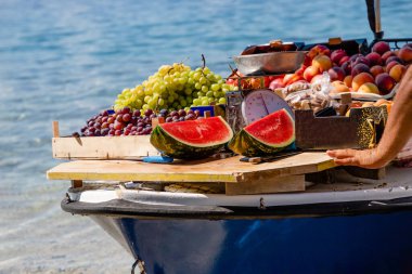 Karpuzlar, yeşil ve mor üzümler, bir teknede şeftaliler, Hırvatistan