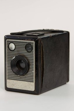 Yıpranmış metal bir önü ve desenli siyah bir kaplaması olan eski model bir kutunun yakın çekimi. Klasik bir 20. yüzyıl ortası tasarımı, geçmişe dönük fotoğrafçılık veya antika dekor meraklıları için mükemmel..