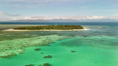 Green Island 'ın hava görüntüleri. Queensland, Avustralya açıklarındaki Büyük Set Resifi' ndeki bir mercan mağarası. Sahne turkuaz suları, uçan resifler, beyaz kumsallar, uzun bir iskele ve iskeleyi ve yoğun tropikal yağmur ormanlarını yakalıyor. Popüler.
