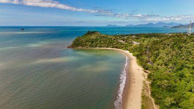 Queensland Avustralya 'nın Cairns Bölgesi' ndeki Ellis Sahili 'nde bu güzel 4K hava aracı görüntülerinde gösteriliyor. Sahne, yumuşak dalgaları ve palmiyeli kıyıları olan uzun ve kumlu bir sahili yakalıyor. Etrafı yemyeşil tepeler ve Mercan Denizi ile çevrili.