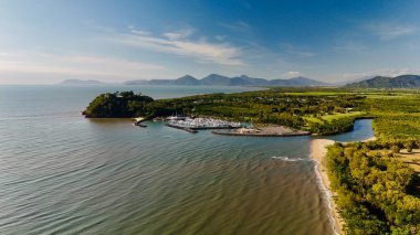 Half Moon Bay Beach 'in ve Cairns, Queensland, Avustralya' daki Yorkeys Boating Club 'ın hava manzarası. Bu manzara kayıklarla dolu marinayı, kıvrımlı sahil şeridini ve kıyı bölgesini çevreleyen yemyeşil alanı yakalıyor.