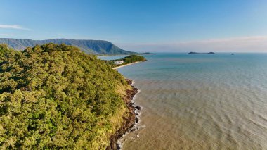 Half Moon Bay Beach 'in ve Cairns, Queensland, Avustralya' daki Yorkeys Boating Club 'ın hava manzarası. Bu manzara kayıklarla dolu marinayı, kıvrımlı sahil şeridini ve kıyı bölgesini çevreleyen yemyeşil alanı yakalıyor.