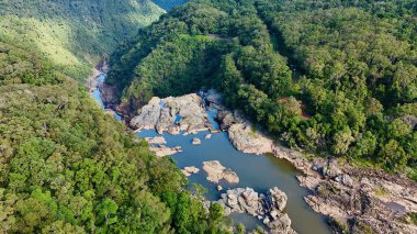 Kuranda, Queensland, Avustralya yakınlarındaki Barron Gorge Ulusal Parkı 'ndaki Barron Falls' un insansız hava aracı görüntüleri. Video, yoğun yağmur ormanlarında çağlayan dramatik şelaleyi görüntülüyor, Kuranda Manzaralı Tren İstasyonu, Centenary Park