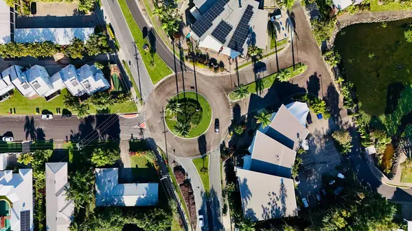 Cairns, Queensland, Avustralya 'daki Trinity Sahili' ndeki kavşağın hava fotoğrafı. Bu canlı kıyı banliyösünde tropikal peyzaj, palmiye çizgili yollar ve yerleşim evleri yer almaktadır. Görüntü döner kavşağın ve kavşağın simetrisini yakalar.