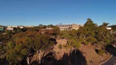 Flinders Üniversitesi, Central Park, Bedford Park, South Adelaide, Güney Avustralya: Bu 4K hava aracı, günbatımında üniversite kampüsünü, modern akademik binaları, geniş karıncaları, çalılıkları ve