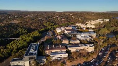 Flinders Üniversitesi, Central Park, Bedford Park, South Adelaide, Güney Avustralya: Bu 4K hava aracı, günbatımında üniversite kampüsünü, modern akademik binaları, geniş karıncaları, çalılıkları ve