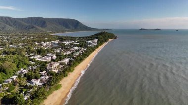 Cairns, Queensland 'daki Trinity Plajı, bu 4K hava aracı görüntülerinde, palmiye ağaçları, Taylor Point burnu, sahil tatil beldeleri ve Mercan Denizi' nin turkuaz sularıyla çevrili manzaralı bir plajı göstermektedir. Görüntüler tropikal bölgeleri gösteriyor.