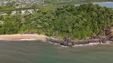 Cairns, Queensland 'daki Trinity Plajı, bu 4K hava aracı görüntülerinde, palmiye ağaçları, Taylor Point burnu, sahil tatil beldeleri ve Mercan Denizi' nin turkuaz sularıyla çevrili manzaralı bir plajı göstermektedir. Görüntüler tropikal bölgeleri gösteriyor.