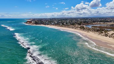 Port Noarlunga Sahili, Güney Avustralya 'da ikonik iskelesi ve resifleriyle bilinen bir kıyı taşıdır. Bu 4K hava aracı görüntülerinde turkuaz sular, kumlu kıyı şeridi, dramatik kızıl kayalıklar ve büyüleyici sahil kasabası görülüyor. Resif, meşhur...