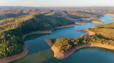 Mount Bold Reservoir, Güney Avustralya 'nın en büyük su depolama tesisidir. Bu hava aracı görüntülerinde geniş bir depo alanı, sarmal su deposu kolları, orman tepeleri ve ikonik tepeler görülüyor.