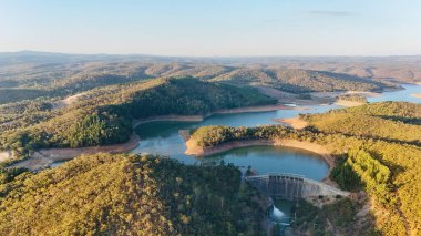 Mount Bold Reservoir, Güney Avustralya 'nın en büyük su depolama tesisidir. Bu hava aracı görüntülerinde geniş bir depo alanı, sarmal su deposu kolları, orman tepeleri ve ikonik tepeler görülüyor.